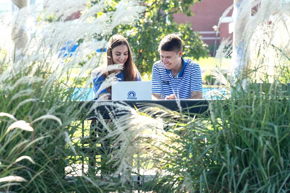 Two students at laptop in a gazebo